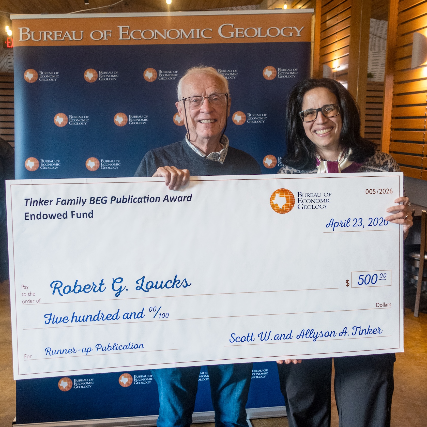 Robert G. Loucks accepts the Bureau’s 2025 Runner-up Publication Award from Director Lorena Moscardelli