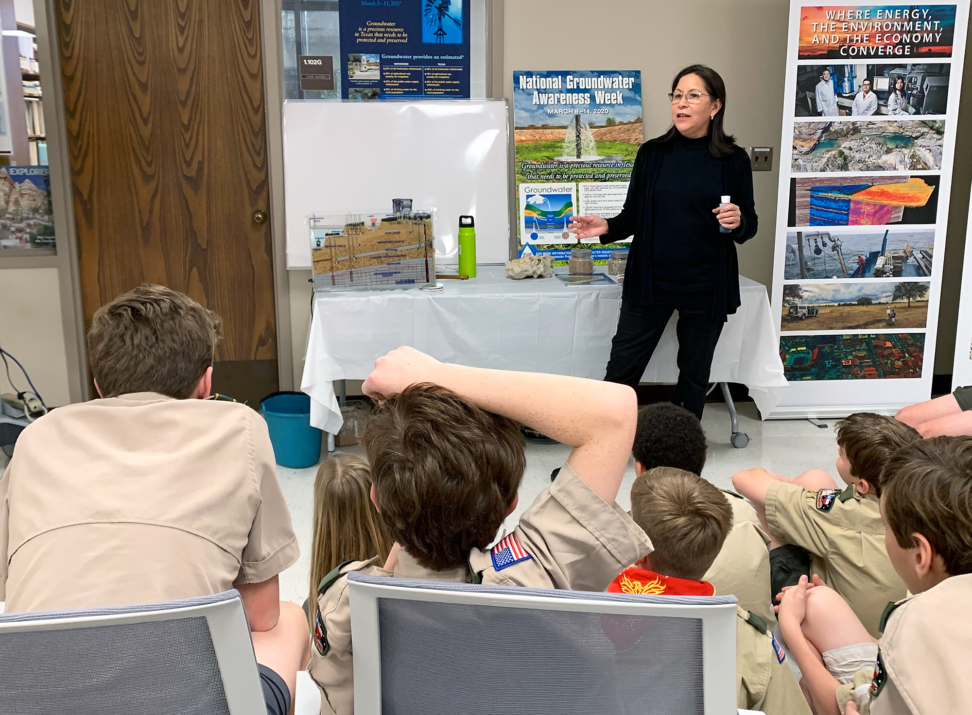 Linda Ruiz McCall demonstrates how water flows through aquifers, lakes, and rivers with the help of a groundwater model.